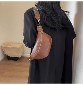 Close-up of vintage brown PU leather crescent bag with ethnic pattern wide strap
