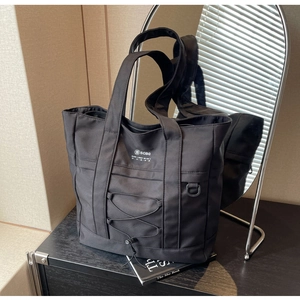Dettaglio della borsa tote in nylon nero con coulisse frontale e logo SCBG stampato