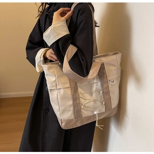 Dettaglio della borsa tote in nylon con corde elastiche decorative e anello a D laterale