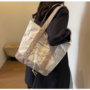 Dettaglio della borsa tote in nylon con coulisse e cuciture a contrasto