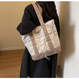 Dettaglio della borsa tote in nylon beige e marrone con anello a D e ampia tracolla comoda