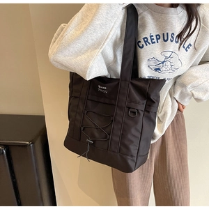 Dettaglio della borsa tote in nylon nero con cordino elastico e anello a D per l'uso