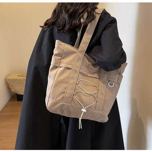 Dettaglio della borsa tote in nylon kaki con coulisse regolabile e gancio ad anello