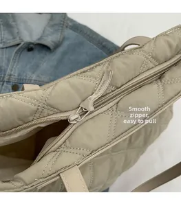 Detail of beige quilted tote bag featuring a high-quality smooth zipper and nylon texture