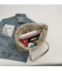 Top view of beige quilted tote bag interior showing large capacity for books and tablet