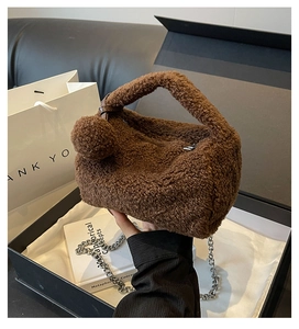 Gros plan du sac oreiller en peluche marron montrant la texture douce et la bandoulière