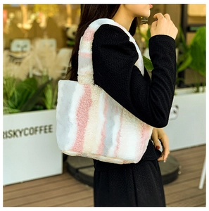 Detail einer weichen Plüsch-Tragetasche mit bunten Streifen in Rosa, Weiß und Grau