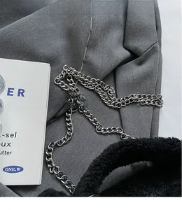 Détail du sac à main en fausse fourrure noire avec une bandoulière en chaîne argentée