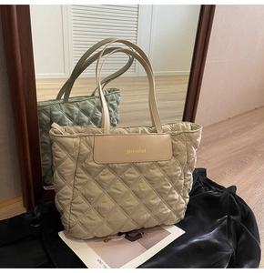 Detail of beige quilted tote bag showing padded texture and premium faux leather handle