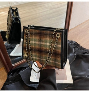 Dettaglio della trama in tweed scozzese e tracolla a catena dorata della borsa tote