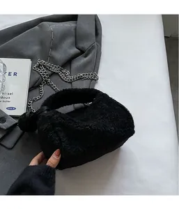 Détail du sac polochon en peluche noire avec bandoulière chaîne argentée et poignée