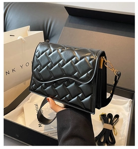 Primo piano dettagliato di una borsa in pelle trapuntata nera in confezione regalo