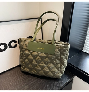 Detail of olive green quilted tote bag with rhombus pattern and long dual shoulder straps
