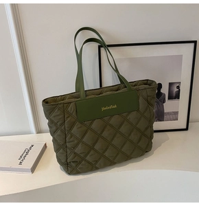 Macro detail of military green quilted tote bag featuring elegant diamond stitching pattern