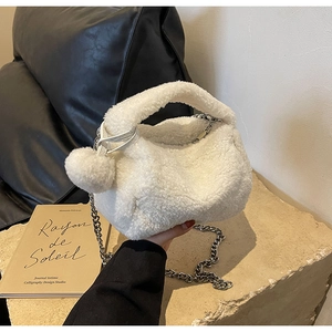 Détail d'un sac en peluche blanche avec chaîne argentée et pompon assorti