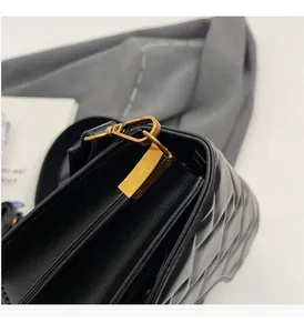 Dettaglio borsa in pelle trapuntata nera con chiusura dorata e soffietto laterale a fisarmonica