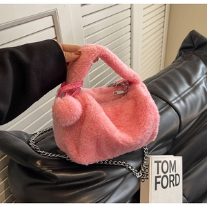Détail du sac oreiller en peluche rose avec chaîne argentée et charmant pompon doux