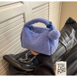 Détail du sac à main violet en fausse fourrure avec chaîne métallique et pompon