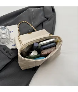Quilted crossbody bag interior showing spacious compartments for essentials and gold chain