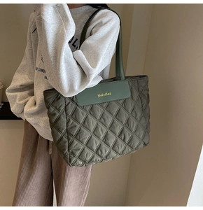 Quilted tote bag detail with diamond stitching and green leather logo patch