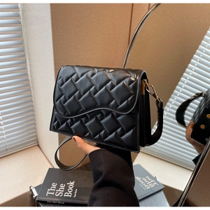 Dettaglio ravvicinato della borsa in pelle nera trapuntata con ganci dorati