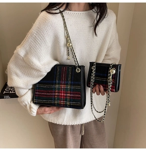 Dettaglio della borsa a catena in tweed tartan rosso e blu con fibbia a sfera dorata