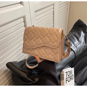 Dettaglio della borsa a tracolla beige trapuntata con patta ondulata e chiusura dorata