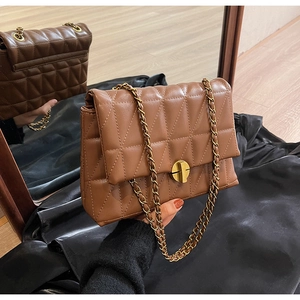 Detail of caramel brown quilted shoulder bag with gold chain and metal twist lock