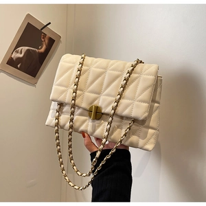 Detail of cream quilted leather crossbody bag with gold cylindrical twist lock