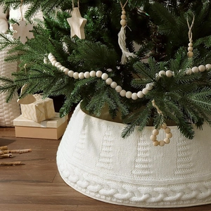 Cream knit Christmas tree skirt with cable knit patterns and festive interior decor