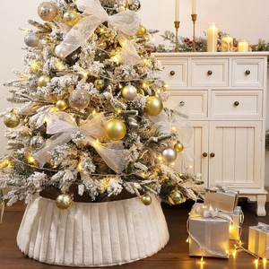 Detail of white faux fur pleated Christmas tree skirt with festive holiday decorations