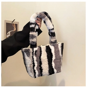 Detail der flauschigen Kunstpelz-Tasche mit modischen schwarzen, weißen und grauen Streifen