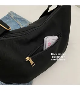 Detailed view of back zipper pocket on black corduroy crossbody bag for small items