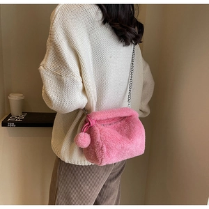 Sac bandoulière en peluche rose avec texture en fourrure et chaîne argentée sur modèle