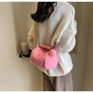 Détail du sac polochon rose en fausse fourrure avec chaîne argentée et pompon doux