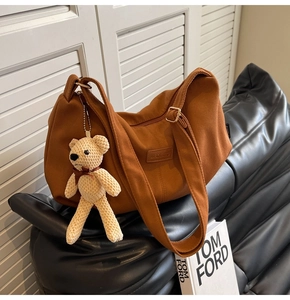 Detail of caramel corduroy hobo bag with adjustable strap and cute knit bear charm