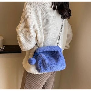 Détail du sac bandoulière bleu en peluche duveteuse avec fine bandoulière en chaîne argentée