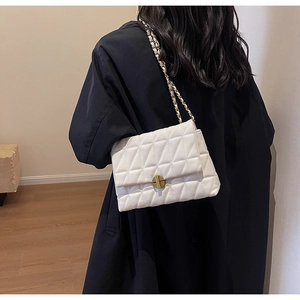 Quilted diamond lattice shoulder bag with gold chain strap shown on model's back