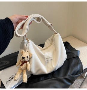 Detail of cream corduroy dumpling bag with Banatu logo and brown bear charm