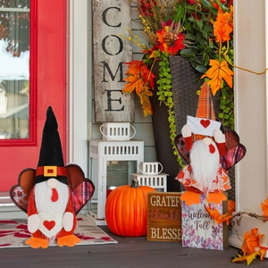 Detail of Thanksgiving gnomes with turkey feathers and heart props on autumn porch