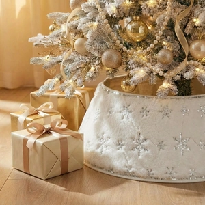 Close-up of white plush Christmas tree skirt with silver sequin snowflakes and edge