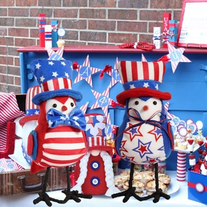 Close-up of USA Independence Day bird dolls and patriotic gnome on a festive blue stand