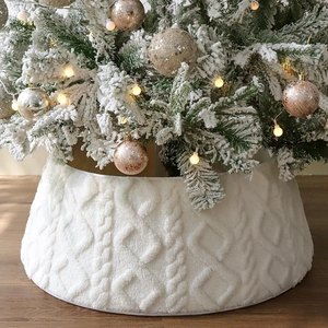Detail of white knit Christmas tree skirt with thick faux fur cable texture pattern