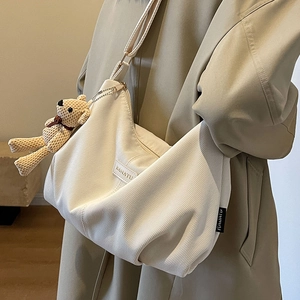 White corduroy crossbody bag with adjustable strap and cute bear pendant accessory