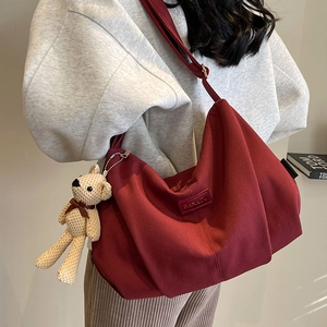 Burgundy corduroy dumpling crossbody bag with adjustable strap and cute bear charm