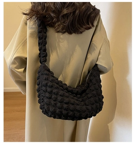 Detail of black popcorn texture fabric on a large crescent shoulder bag with zipper