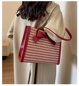 Vista dettagliata della borsa tote pied de poule con fiocco in pelle rossa e tracolla