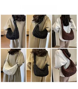 Three colors of padded puffer shoulder bags showing side view of the crescent design