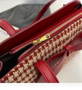 Dettaglio borsa tote in pelle rossa con tessuto pied-de-poule e zip dorata scorrevole