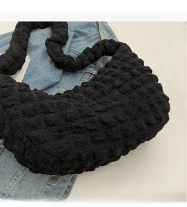 Detail shot of black nylon bubble texture fabric on a large crossbody hobo bag